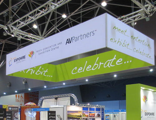 What are the benefits of using a hanging banner over my exhibition stand?
